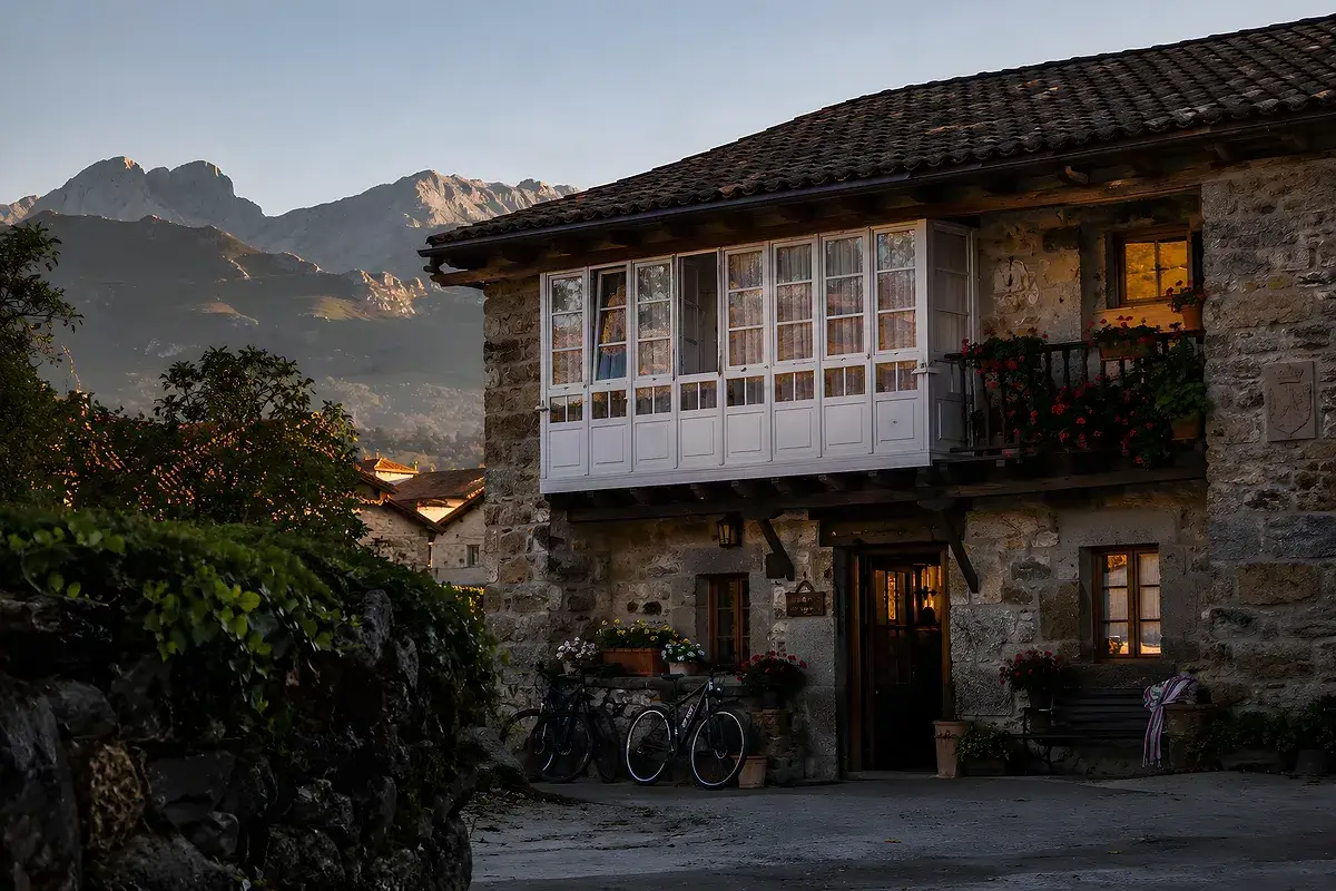Casa rural asturiana de piedra con galería acristalada y bicis aparcadas