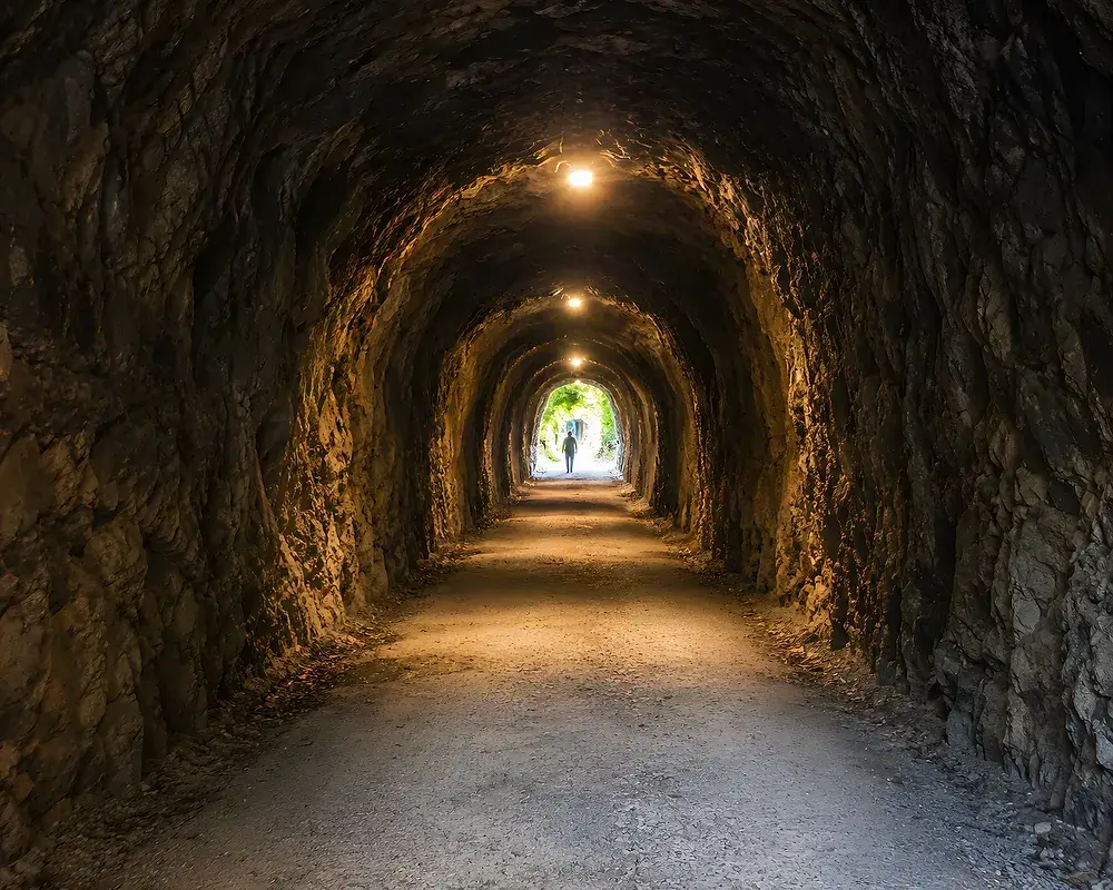 Interior de un túnel de la senda iluminado con farolas solares
